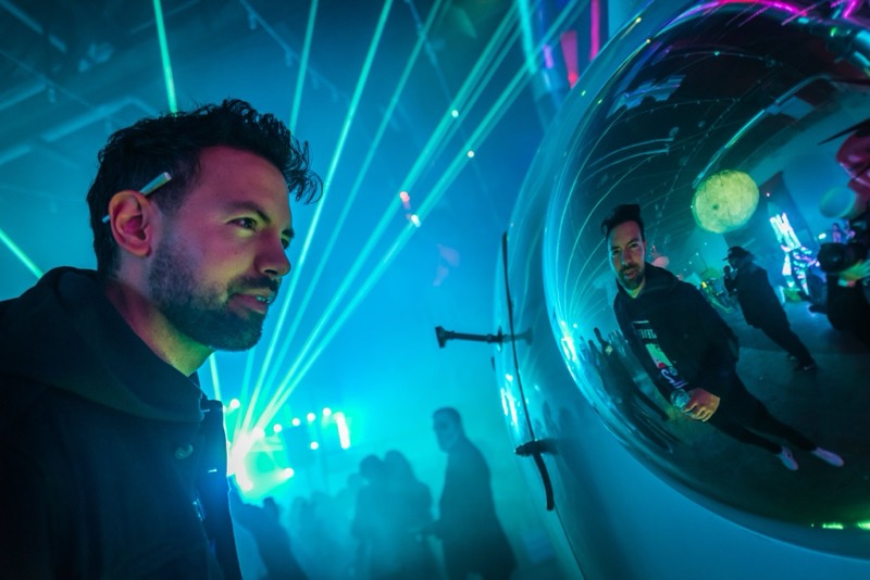 Face to face with a mirrored bubble under teal lasers at Coloween 2019 in Colorado