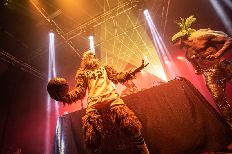 Furry sasquatch in a basketball jersey palming a ball on the DJ booth at Denver's Coloween Halloween party