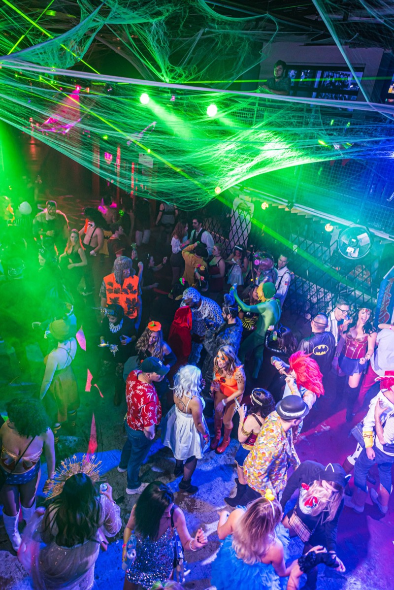 Green lasers rake a dancefloor full of superheroes and cowboys at Coloween's Halloween costume party