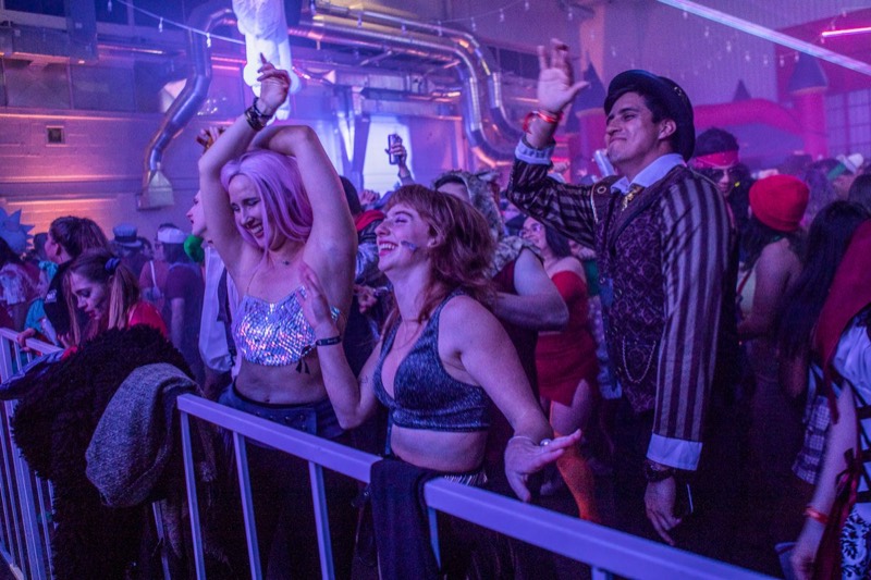 Two friends dancing at the front rail in purple haze