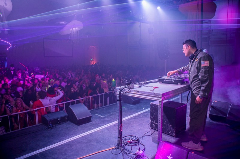 DJ drops a set over a sea of costumed dancers at Coloween's Halloween costume party