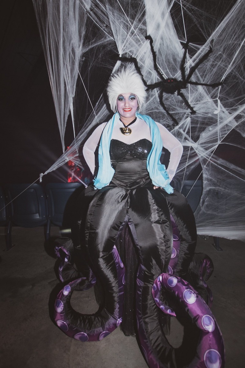 Sea witch costume with inflatable purple tentacles under the web wall
