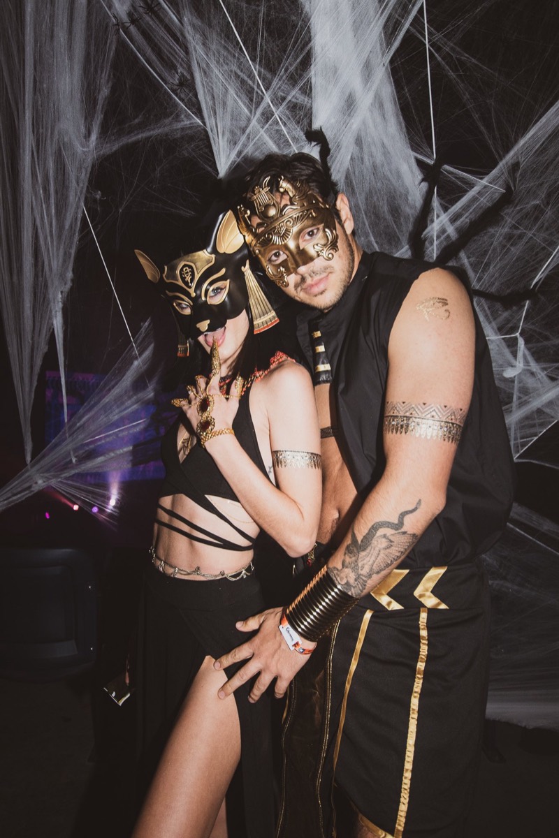 Couple in gold Egyptian masks posing deep in the spider webs at Colorado's biggest adult Halloween party