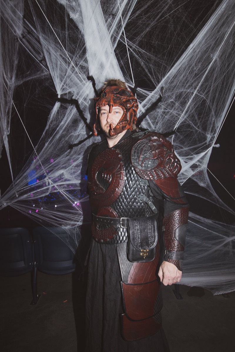 Hand-built dragon-scale armor and horned skull helmet in full detail on the dance floor at Coloween 2022