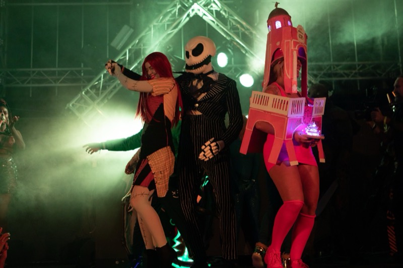 Costume contest dance-off beside a light-up clock tower costume at Denver's Coloween Halloween party