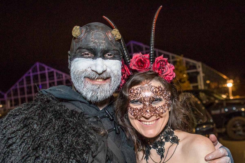 Horned demon face paint next to a copper filigree mask and roses