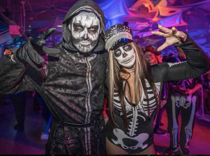 Skeleton couple in a rhinestone captain hat strike claw poses at Coloween 2025 in Colorado