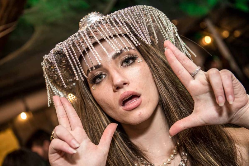 Close-up of a rhinestone-fringe headpiece framing playful wide eyes at the Coloween costume contest in Denver