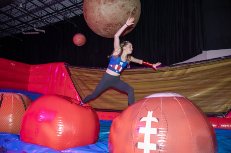 Captain America clears the giant footballs with planets overhead at Denver's Coloween Halloween party