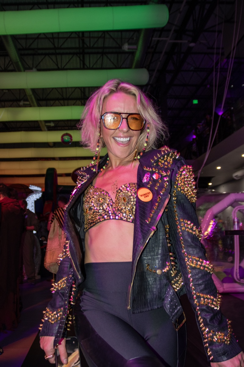 A gold-studded moto jacket cracks up in the neon glow at Coloween, Denver's 21+ Halloween party