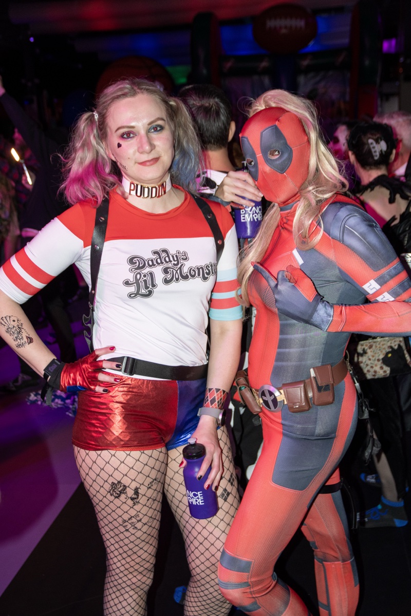Harley Quinn and Deadpool call a truce for the camera on the dance floor at Coloween 2025