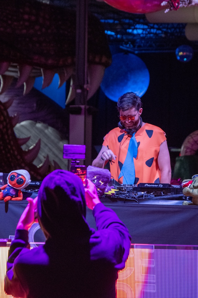 Fred Flintstone spins from inside the dinosaur's mouth at Coloween, Denver's 21+ Halloween party