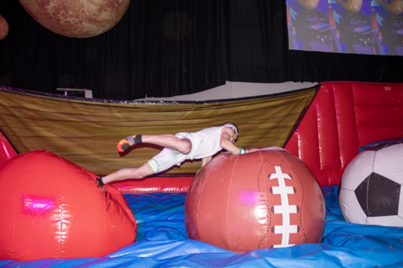 Retro gym shorts, fully airborne over the giant football at Colorado's biggest adult Halloween party