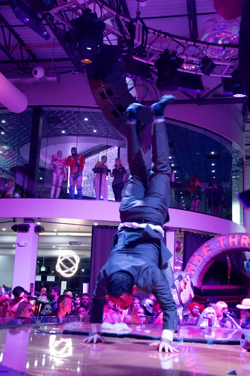 A handstand on the runway while two floors watch at the adults-only Coloween Halloween event